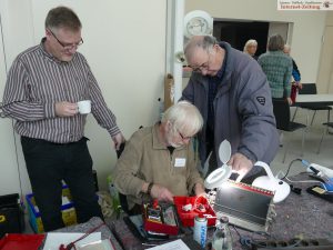 Pfarrer Jörg Geissler (l) beobachtet Franz Schulz bei der Reperatur eines Toasters