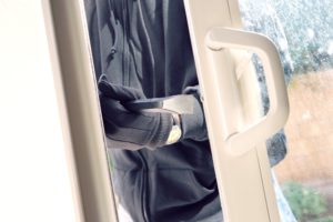 Einbrecher bricht in ein Haus ein