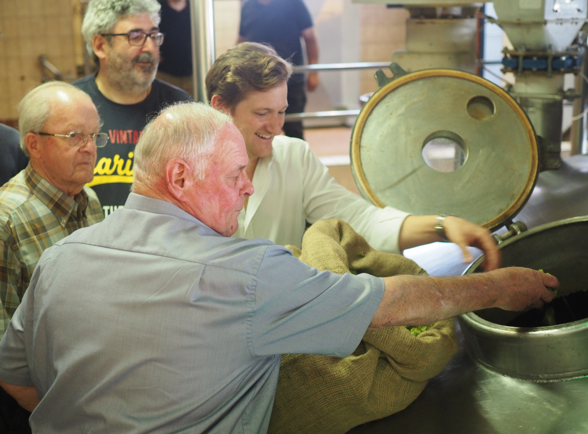 Sandhäuser Delegation gibt bei Welde selbstgeernteten Hopfen in den Sud