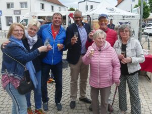 Gruppe von Menschen beim Europatag mit Getränken in der Hand auf dem Markt in St. Ilgen.