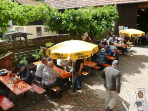 Gesamtansicht des Festes mit Biertischen und Sonnenschirmen im Innenhof
