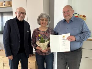 Bürgermeisterstellvertreter Richard Bader gratuliert Doris und Wolfgang Gast in Leimen zur Goldenen Hochzeit; das Ehepaar hält Blumen und Urkunde.